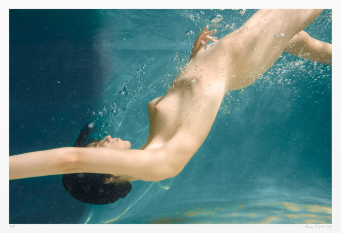 Underwater nude artwork, female plummets into cerulean waters